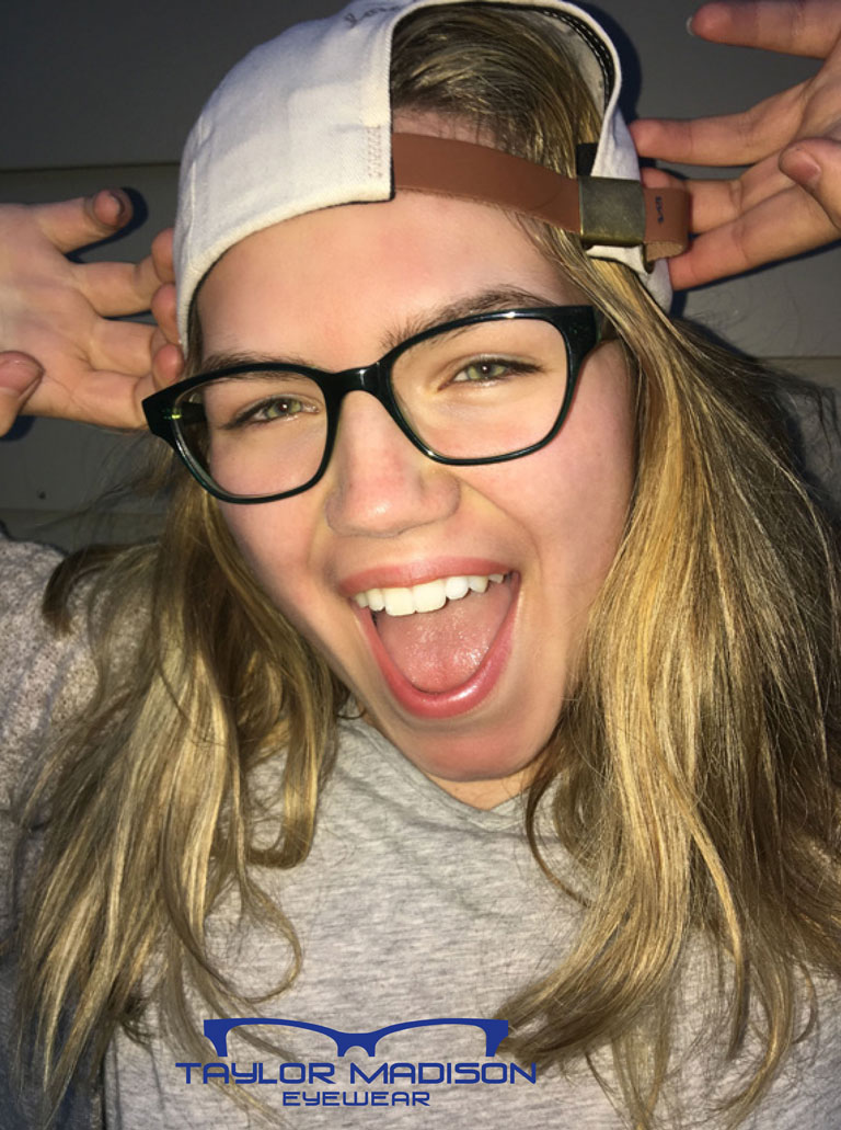 young woman wearing glasses and baseball cap